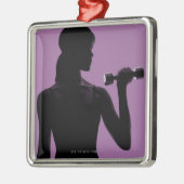 meisje dat dommel optilt op paarse achtergrond metalen ornament (Links)