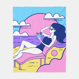 meisje zonnebaden op het strand met een cocktail i fleece deken