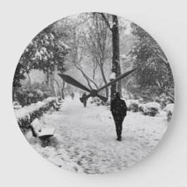 Mensen in het park op sneeuwwinterdag grote klok