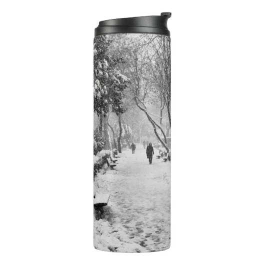 Mensen in het park op sneeuwwinterdag thermosbeker (Gedraaid links)