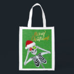 Merry Christmas Skeleton Santa Hat Ornamenten Groe Boodschappentas<br><div class="desc">Deze canvas tas heeft een grappig skelet met een rode bont getrimde kerstmuts met twee glanzende ornamenten tegen zijn ogen op een groene achtergrond met faux gouden sprankels en de tekst Merry Christmas in felgoud op de voor- en achterkant.</div>