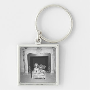 Miniatuurpooiën die voor de haard zitten sleutelhanger