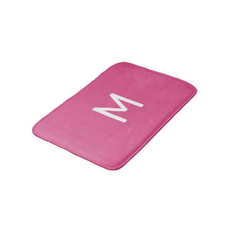 Minimalistisch wit monogram op roze badmat
