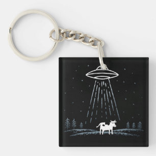 Minimalistische illustratie van een UFO die een ko Sleutelhanger