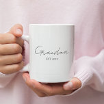 Minimalistische oma EST 2025 | Gepersonaliseerd ca Koffiemok<br><div class="desc">Vier een speciale mijlpaal met deze minimalistische oma EST 2025 gepersonaliseerde mok - een perfect cadeau voor een eerste keer oma! Deze mok is ontworpen met een elegante moderne typografie op een heldere witte achtergrond en is zowel betekenisvol als stijlvol. Pas het jaar aan om haar nieuwe hoofdstuk te markeren...</div>