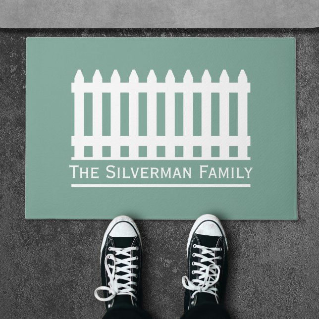 Minimalistische witte hek op groene familie deurmat (Minimalist White Picket Fence on Green Family Doormat)