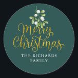 Misteltoe-script goud vrolijk kerst familienaam ronde sticker<br><div class="desc">Misteltoe script goud Kerstmis familienaam klassieke ronde sticker. Delicate waterverf mistletoe groen hangt boven chic goud script Vrolijk Kerstmis typografie op deze elegante stickers. Personaliseer met uw familienaam. U kunt de achtergrondkleur aanpassen aan uw vakantiethema. Ontworpen door Thisisnotme</div>