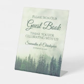 Mistige groene dennenbomen onderteken ons gastenbo reclamebord met voetstuk (Voorkant)