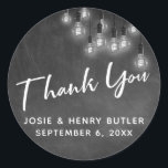 Modern Chalkboard & Edison Lights Dank u Ronde Sticker<br><div class="desc">In dit bruiloft-thema ontwerp heb ik een elegant, modern kalligrafie lettertype gebruikt om een witte grafische typografie overlay voorlezen te creëer. De achtergrond werd bedekt met een afbeelding met een getextureerd krijtbord. Bedekken dat is een cluster van ronde witte Edison lichten. Vul de sjabloon blanks in met uw gegevens om...</div>