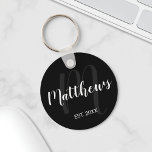 Modern persoonlijk monogram en familienaam zwart sleutelhanger<br><div class="desc">Gepersonaliseerde Monogram en de Gift van de Naam van de Familie met familienaam in witte moderne manuscriptdoopvontstijl en monogram in grijze moderne manuscriptdoopvontstijl als achtergrond met gevestigd jaar in witte sans serif doopvontstijl op zwarte achtergrond. Ideaal als cadeau voor nieuwigheden,  vakantiecadeau voor familie,  gezinshereniging en cadeau voor speciale gelegenheden.</div>