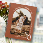 Modern Photo Arch Terracotta Wedding Planner<br><div class="desc">Een elegante spiraalverbindende trouwplannerkalender kenmerkt uw foto in een unieke boogvormende lay-out op een terracotta achtergrond, voegen uw namen met een grote witte ampersand bij de bodem en uw trouwdatum die bij de bovenkant wordt gearchiveerd. Verander de kleur van het boek op de voor en terug om uw foto aan...</div>
