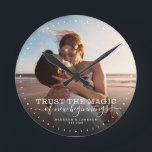 Modern Quote Love Wedding Photo Pas getrouwd Ronde Klok<br><div class="desc">Aangepaste moderne kikkerfotoklok met handgeschreven script en moderne typografie lezen:' Vertrouw op de magie van nieuw begin 'naast je eigen namen en trouwdatum. Pas uw favoriete foto en informatie aan. Geweldig geschenk voor newlyweds,  een gedenkdag of Valentijnsdag!</div>