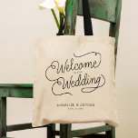 Modern Script Gold Welkom op onze huwelijksavor Tote Bag<br><div class="desc">Deze moderne canvas tas met een minimalistisch casual ontwerp van de manuscriptkalligrafie die WELKOM AAN ONZE WEDDING lezen evenals uw douanenamen en datum van steunen kenmerkt schone lijnen aan creëer een gestroomlijnde en verfijnde verschijning. De ondergewaardeerde stijl met de kleine goudkleurige gouden hartdetails voegt een beetje verfijning toe aan je...</div>