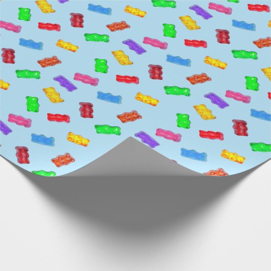 Moderne meerkleurige zoete beren op blauw cadeaupapier (Hoek)