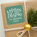 Moderne Script Green Merry kerst Custom Vierkante Sticker<br><div class="desc">Stijlvolle kerstvakantie met vrolijke feestdagen sticker is uitgerust met witte scripts en accenten van takken met heilige bladeren en bessen. Pas aan met douanenaam/familie en jaartekst. De groene achtergrondkleur kan worden gewijzigd.</div>