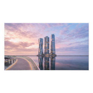 Moderne wolkenkrabbers bij rustig water bij zonsop foto afdruk