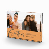 Moderne zussen houden twee foto's Bleek Sinaasappe (Rechts)