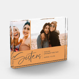 Moderne zussen houden twee foto's Bleek Sinaasappe