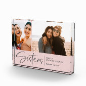 Moderne zusters houden twee foto's bloost roze (Rechts)