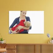 Moeder geeft haar baby. canvas afdruk (Insitu (Woonkamer))