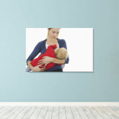 Moeder geeft haar baby. canvas afdruk (Insitu (Houten vloer))