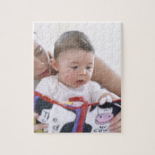 Moeder leest naar baby jongen. Tegenover een moede Legpuzzel