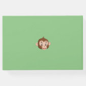 Monkey op een toonboek over een wijnontwerp gastenboek (Achterkant)