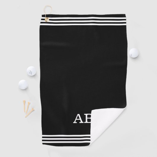 Monogram en drie strips op zwart golfhanddoek (Insitu)