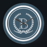 Monogram ontwerp grote klok<br><div class="desc">Monogramontwerp met laurelvormig vormgestreepte vormgeving op blauwe achtergrond</div>