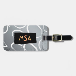 Monogram op zwart op zilveren achtergrond met witt bagagelabel