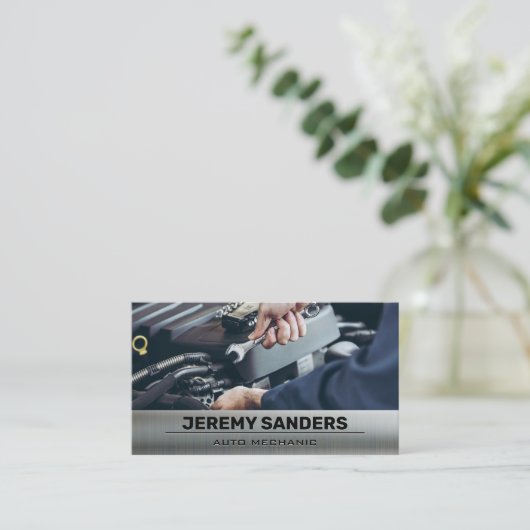 Monteur met behulp van moersleutel op de motor visitekaartje (Staand voorkant)