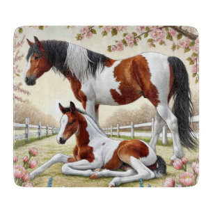 Mooi paard en veulen in een bloeiende boomgaard snijplank