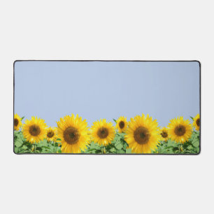 Mooie zonnebloemen tegen een luchtblauwe achtergro bureaumat