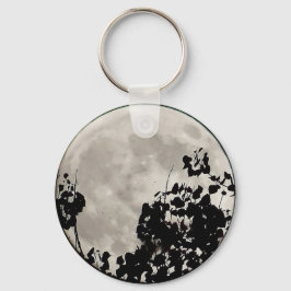 Moon achter donkere bladeren sleutelhanger