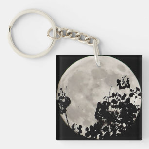 Moon achter donkere bladeren sleutelhanger