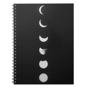 Moonfasen en -knipsels in zwart-wit notitieboek
