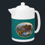 Moose in de Meadow Theepot<br><div class="desc">Een mammemoer en haar schattige kalf met een meer en bergen in de verte. De tekst die "Alaska"in een sneeuwbedekte doopvont lezen verschijnt ook. U kunt een andere achtergrondkleur kiezen.</div>