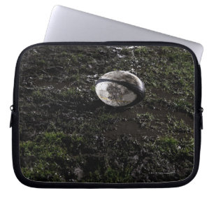 Muddy rugby ball zit op een kauwgras. laptop sleeve