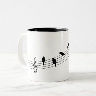 Muziekbalk met vogels als muzieknoten. tweekleurige koffiemok