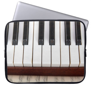 muzieknotities op de achtergrond van een pianoakoe laptop sleeve