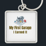 My First Garage Keychain – I Earned It – Proud Fir<br><div class="desc">Celebrate the pride of owning your very first garage or workshop! This keychain features the bold phrase "My First Garage – I Earned It", perfect for anyone who worked hard to achieve this milestone. Whether it’s a personal garage, auto repair shop, or mechanical workshop, this keychain is a fun and...</div>