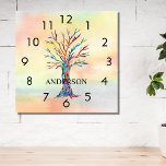 Naam Monogram Regenboogboom Square Wall klok<br><div class="desc">Deze kleurrijke wandklok is versierd met een mozaïekboom in de kleuren van de regenboog op een waterverf achtergrond. Eenvoudig aan te passen met jouw naam of monogram. Omdat we ons eigen kunstwerk creëer,  zal je dit exacte afbeelding niet vinden van andere ontwerpers. Originele mozaïek en Waterverf © Michele Davies.</div>