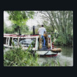 NARROWBOATS PUZZEL<br><div class="desc">Een kunstontwerp van een man dat zijn narrowboot langs het kanaal stuurt. Kanaalboten, in het Verenigd Koninkrijk bekend als narrowboten, werden oorspronkelijk gebruikt om goederen door het land te vervoeren. Ze worden nu voornamelijk gebruikt voor vrijetijdsbesteding en trekken mensen uit de hele wereld aan om van ons platteland te genieten....</div>