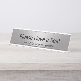 Neem plaats, wij zullen met u zilver zijn bureau naambordje