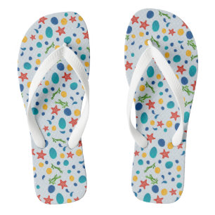 Oceaanstrand met zeesterren, schelpen en steentjes teenslippers