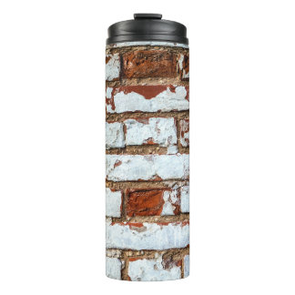 Old vintage brick wall with sprinkled white plaste thermosbeker
