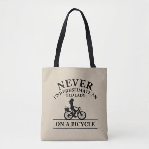 Onderschat nooit een oude dame op een fiets tote bag