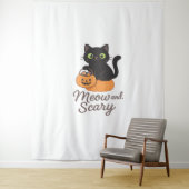 Ondeugende zwarte kat met gloeiende groene ogen op wandkleed (In situ)