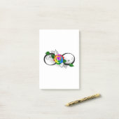 Oneindigheidssymbool met regenboogroos post-it® notes (Op bureau)