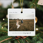 Onze 1e verloofde kerstfoto Keepsake Keramisch Ornament<br><div class="desc">Een stijlvol kerstboom ornament met klassieke typografie "Our first christmas engaged" in zwart op een eenvoudige witte achtergrond. De foto, tekst, naam/jaren en het jaar kunnen eenvoudig worden aangepast om dit ornament uniek en persoonlijk voor u te maken. Een eenvoudig, minimalistisch en eigentijds kerstontwerp om uw verloving aan uw geliefden...</div>